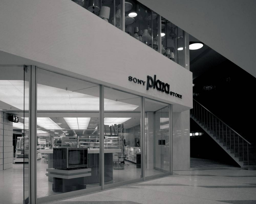 Basement exterior (black-and-white). The sign for the Sony Plaza Store is displayed where the building connects to the Ginza Station underground concourse.