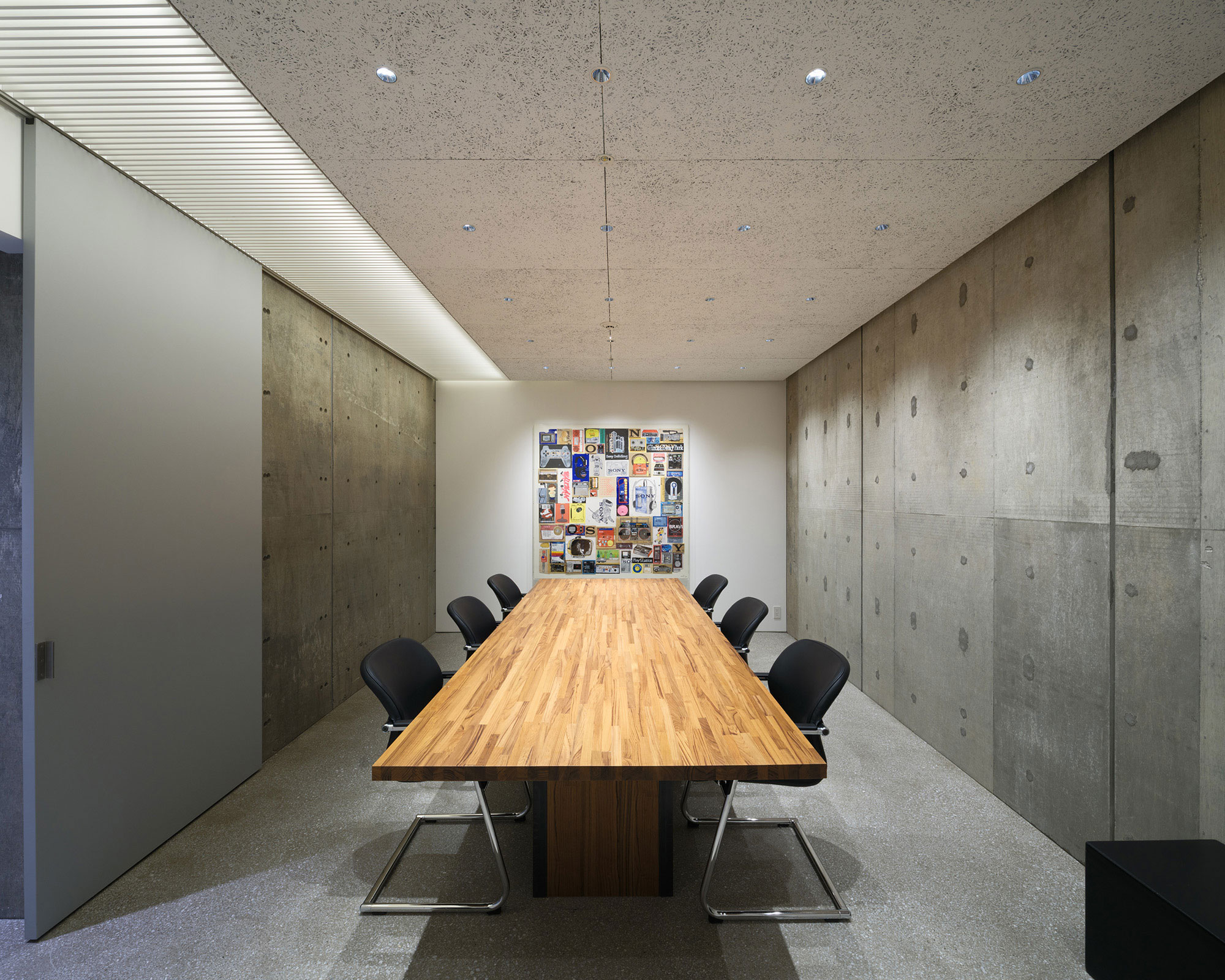 An interior photo of a private room. A painting is displayed on the wall behind the table seating.