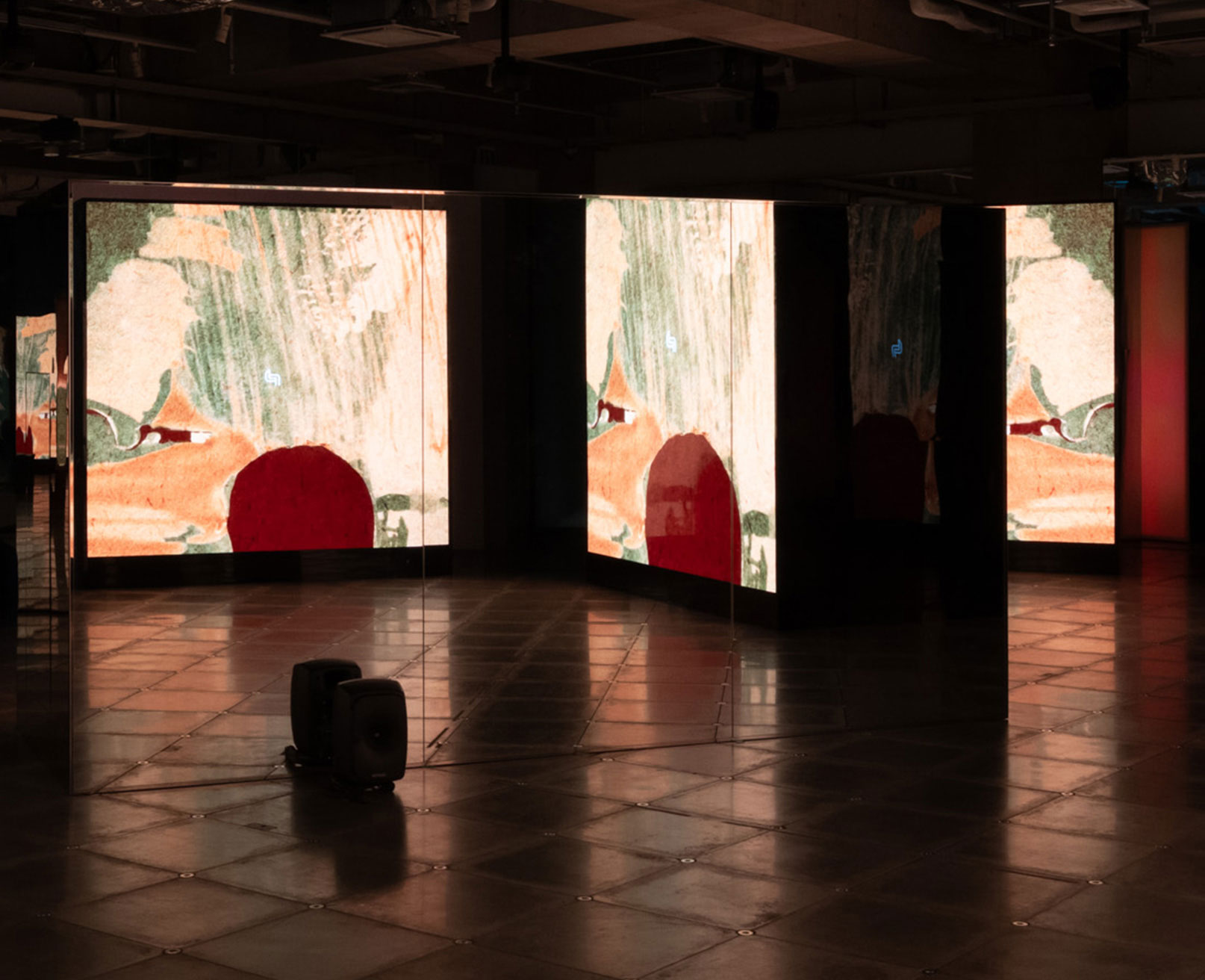 Exhibit. Multiple screens in a dimly lit space display animations.