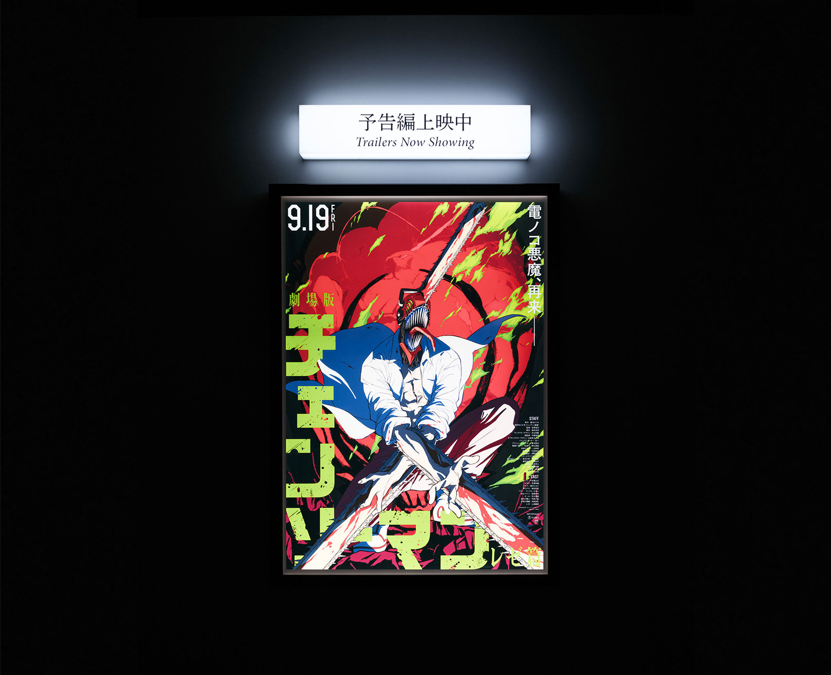 Exhibit. In a dark setting, a lit-up poster of the Chainsaw Man movie is displayed.
