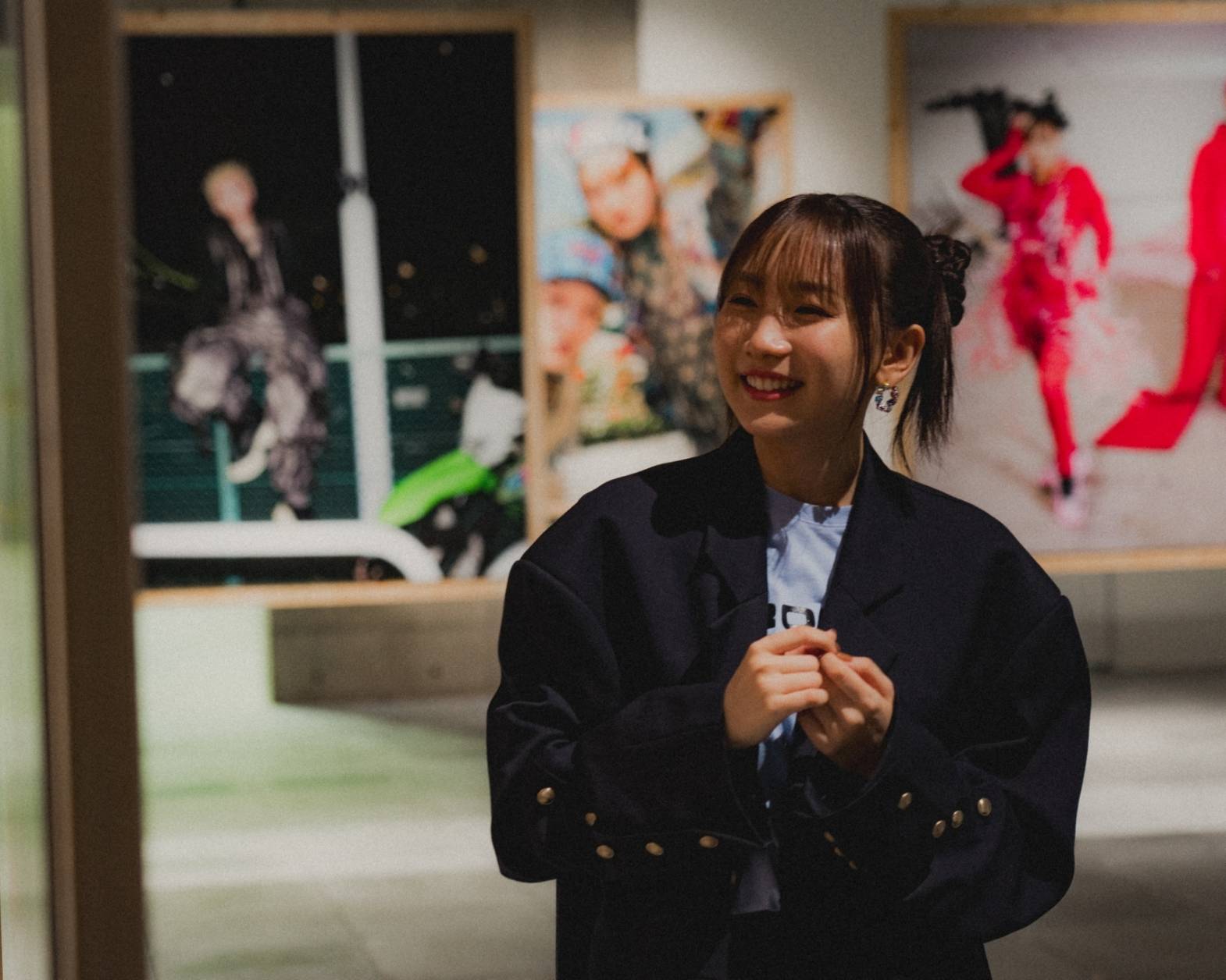 A hands-on experience. Ikura smiling while looking at the photos displayed in the exhibit space.