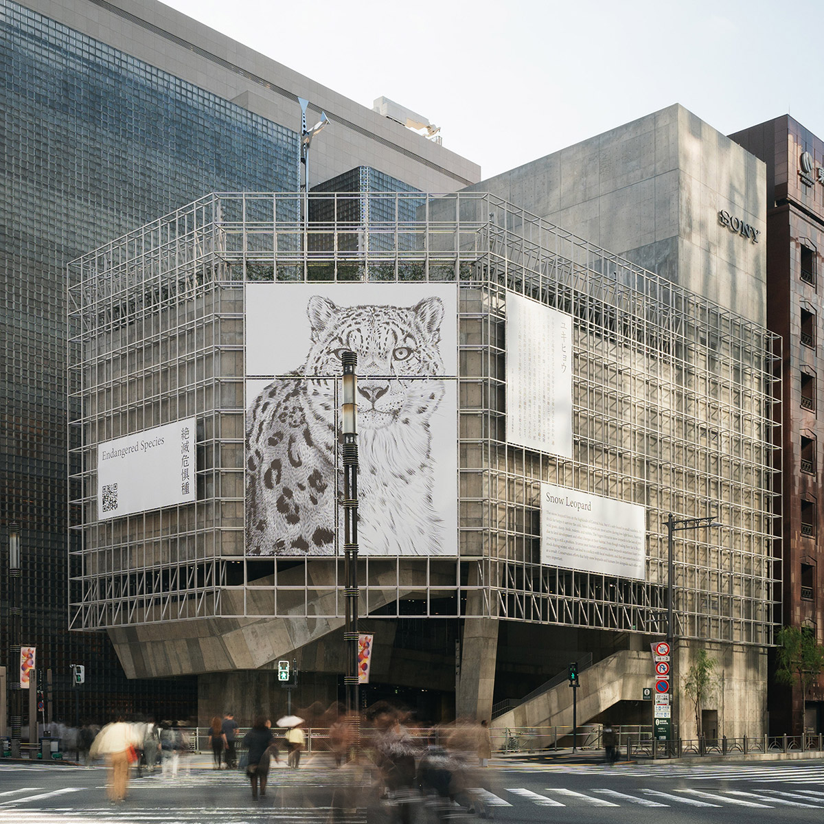 An exterior photo of the building, viewed from across the crossing. The stainless steel grid frames covering the concrete structure are adorned with monochrome banners depicting animals.