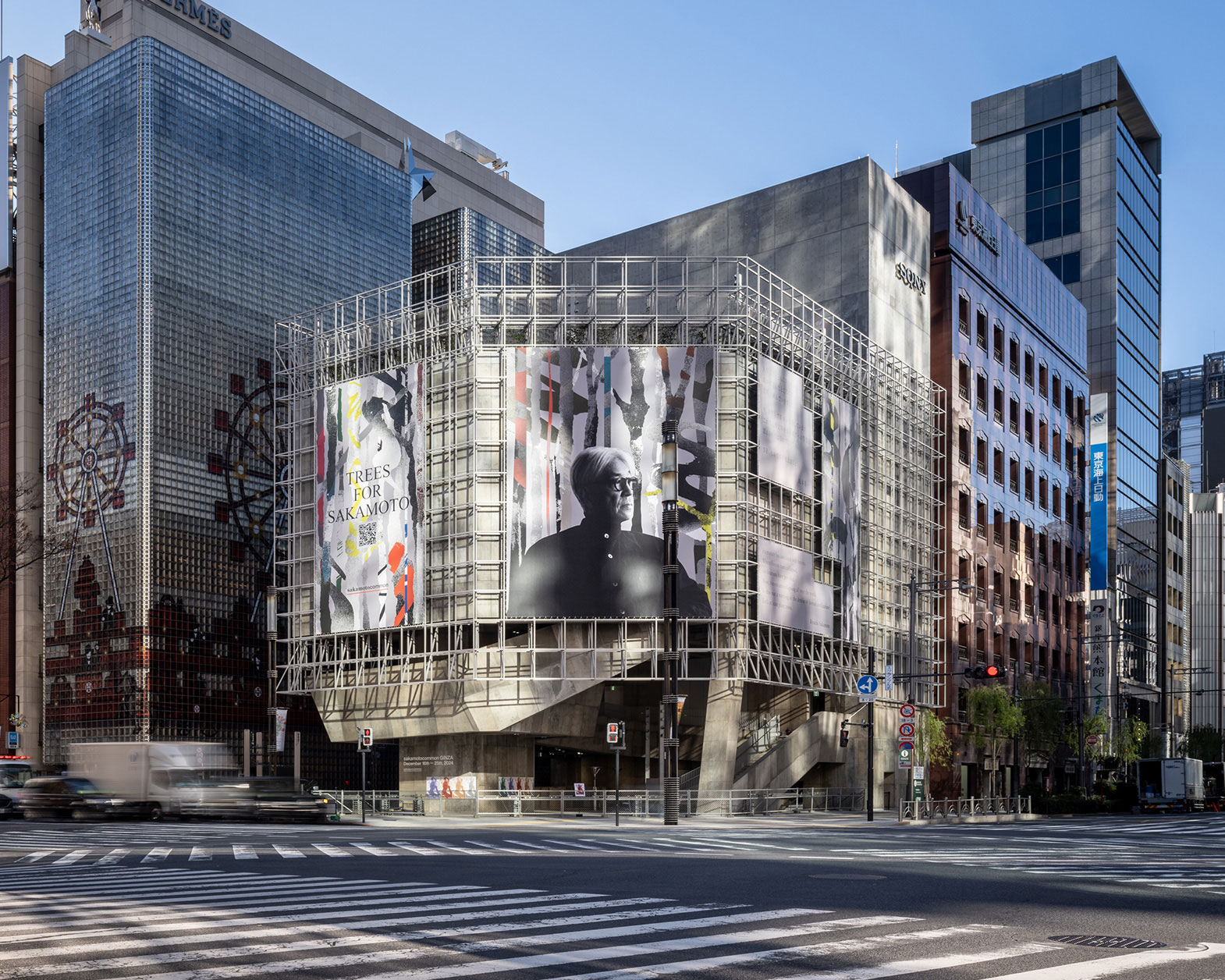 The building's wall displays visuals of "Trees for sakamoto."