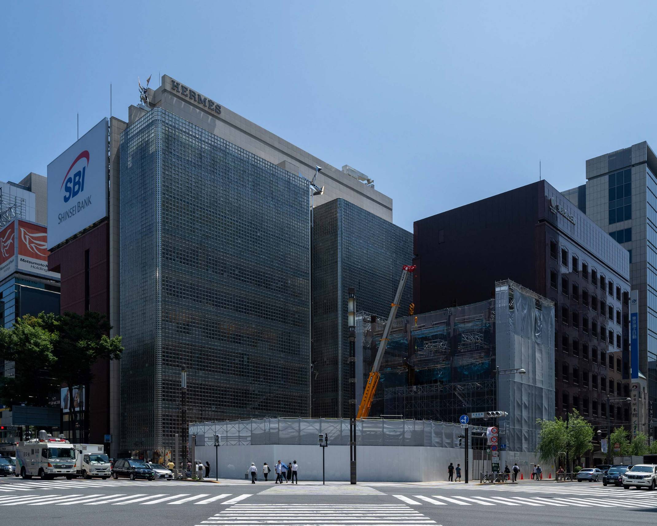 Exterior. Ginza Sony Park during its construction, as seen from Sukiyabashi Crossing. The steel frame for the tower extends all the way down to the third floor.
