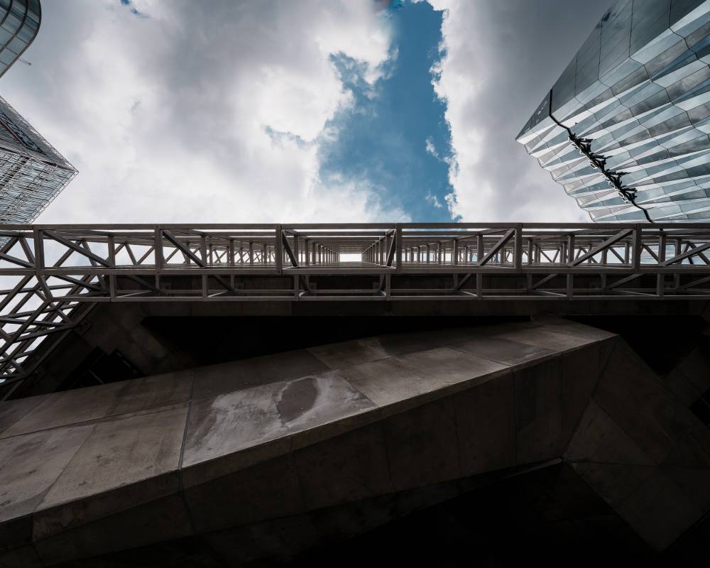 Exterior. A partly sunny sky, as seen looking up through the grid-like façade.