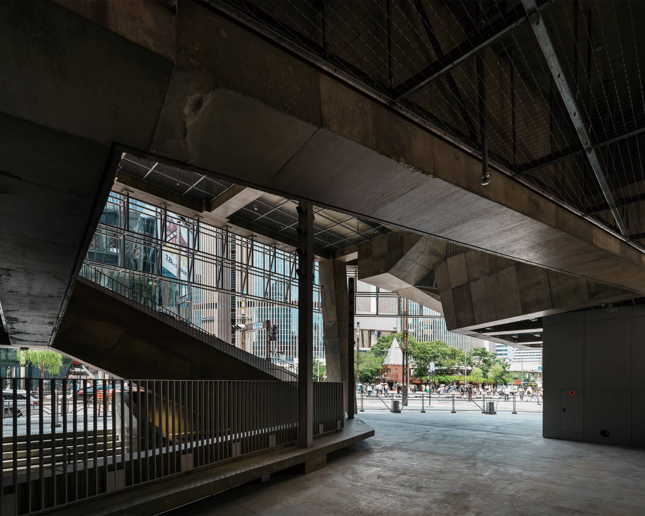 Interior. The atrium space, surrounded by concrete staircases, connects seamlessly out into Sukiyabashi Crossing.