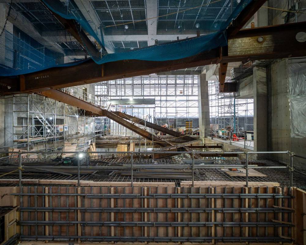 Interior. Concrete formwork and the steel frame for the staircase in the atrium space during its construction, as seen from Sony Street.