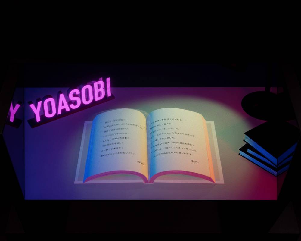 Exhibit item. A 3D CG novel and a “YOASOBI” electric sign are projected onto a monitor.