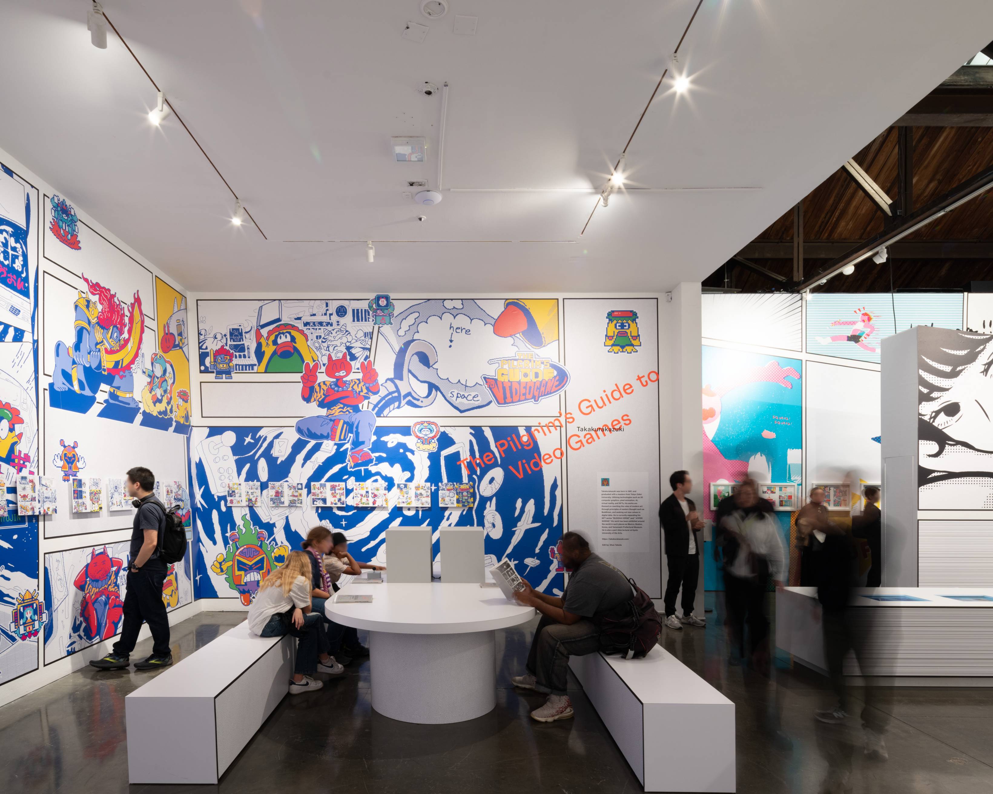 A hands-on experience. Visitors enjoy manga in a variety of ways, looking at the exhibits on the walls, the monitors in the table, books, and more.