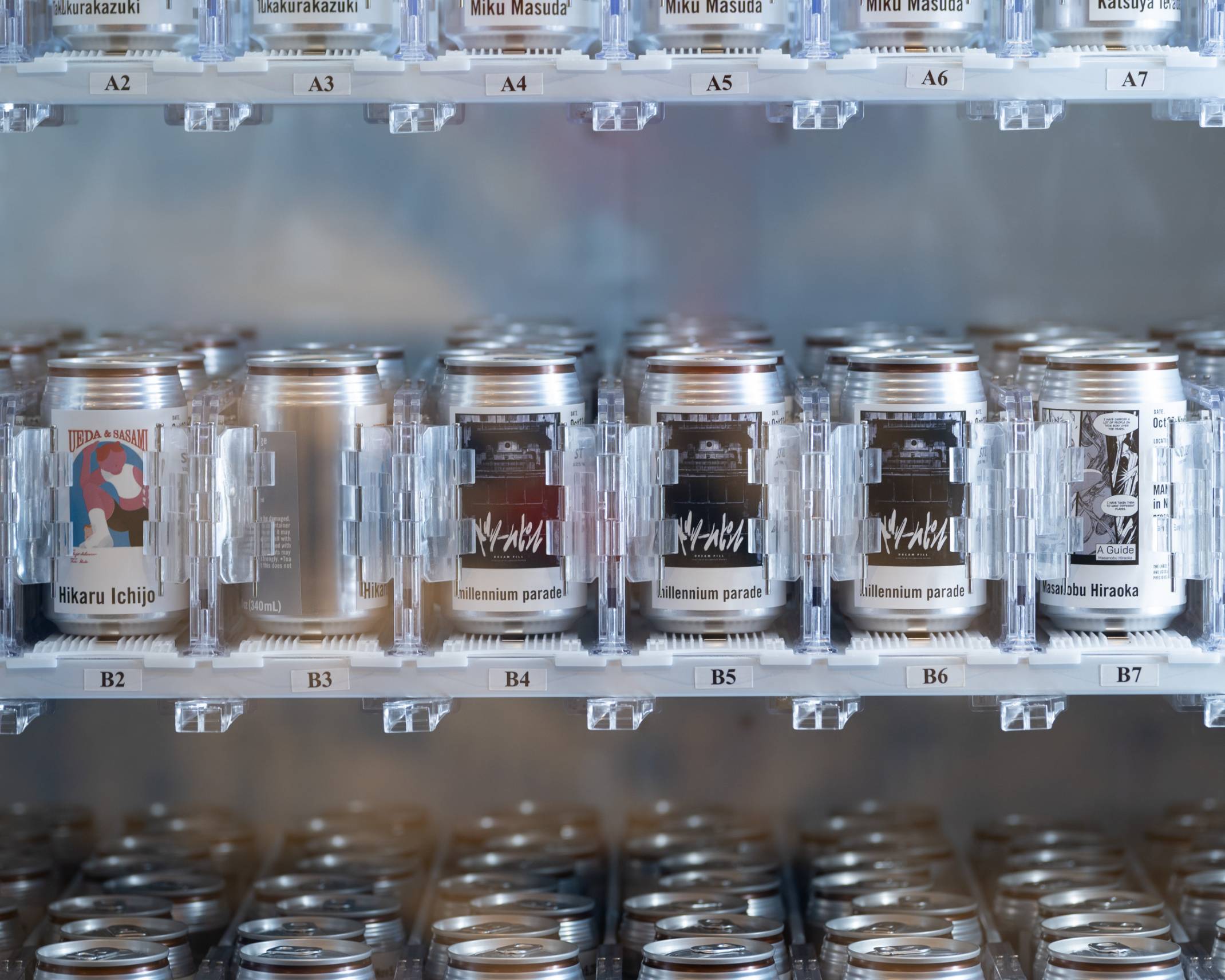 Photo of the “Manga Cans.” A vending machine lined with canned drinks, each printed with drawings from the different manga.