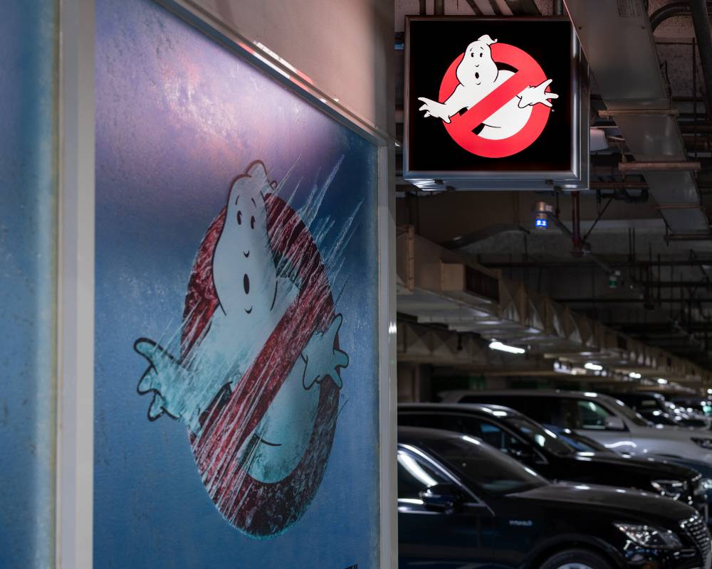 Exterior. The glass window and signboard of the exhibition space, decorated with the Ghostbusters “No ghost” mark.