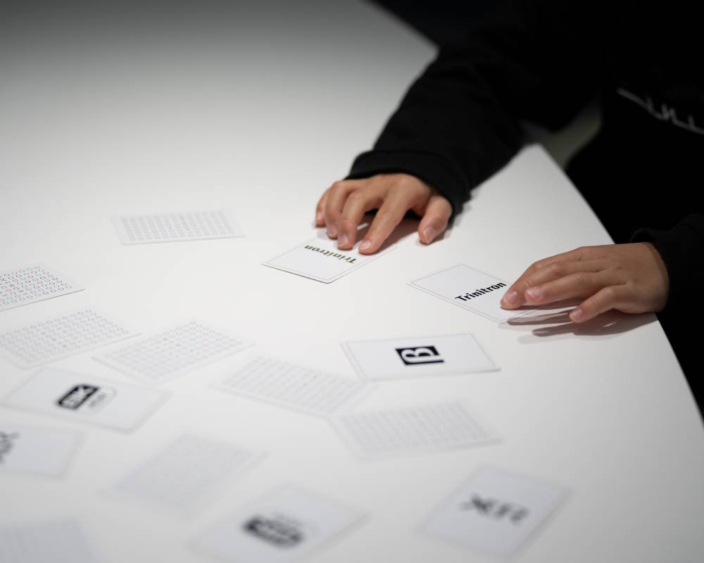 A hands-on experience. A visitor plays with cards printed with the logos of various technologies.
