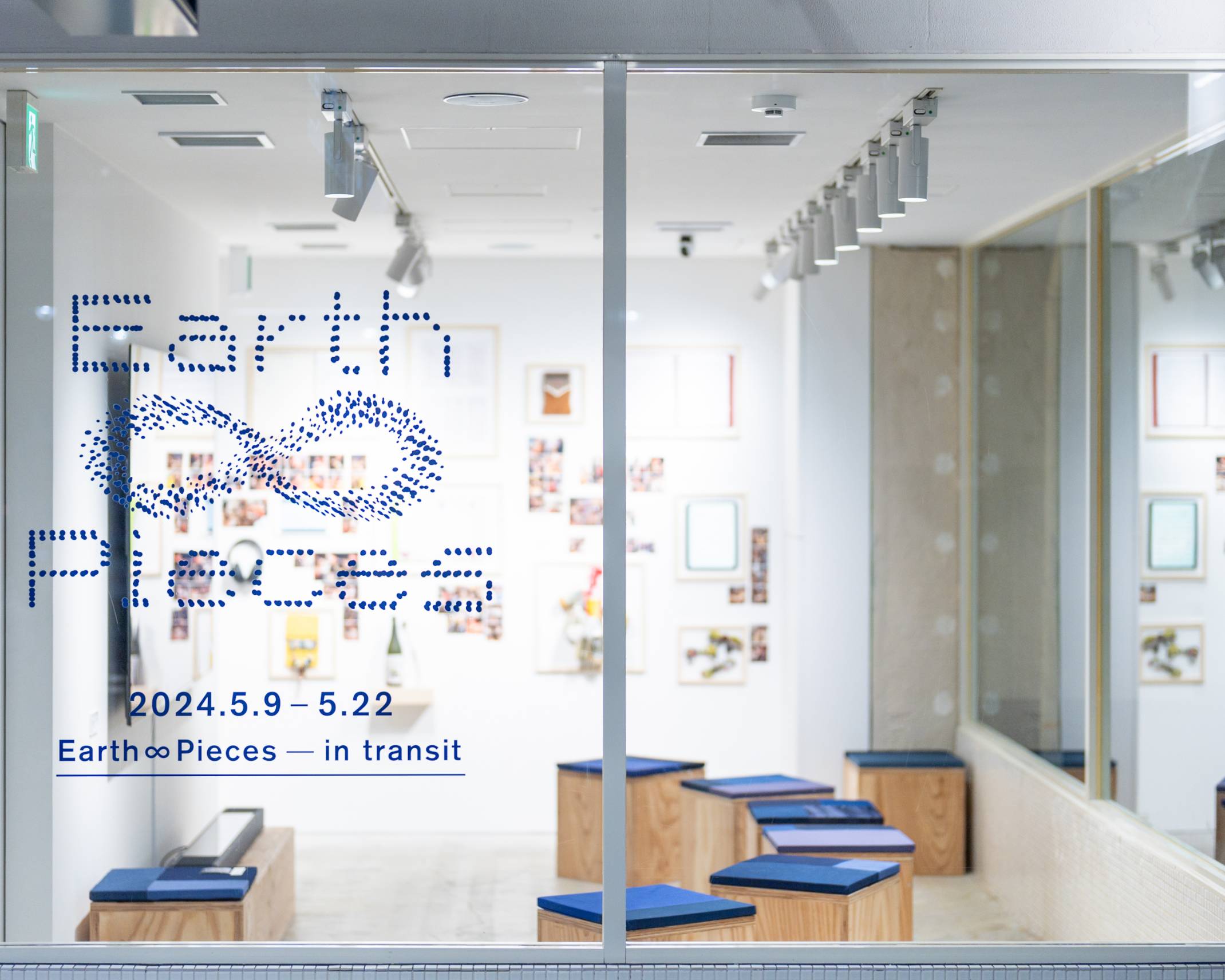 Exhibit. The exhibition space features rows of stools with blue seats, with exhibits lining the back wall.