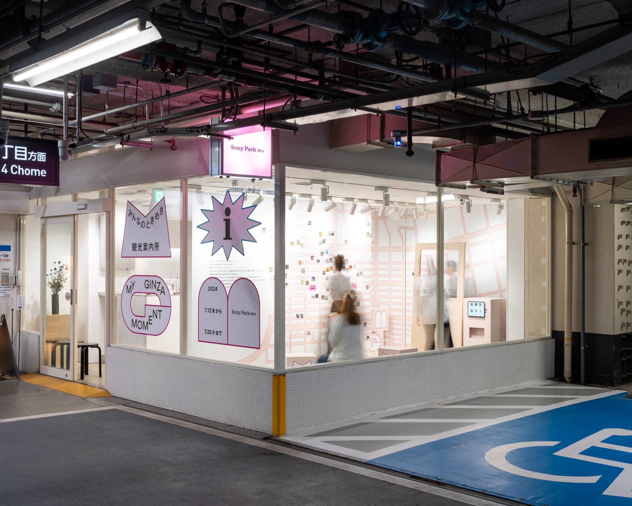Exterior. The walls of the exhibition space are decorated with a large map and photos.