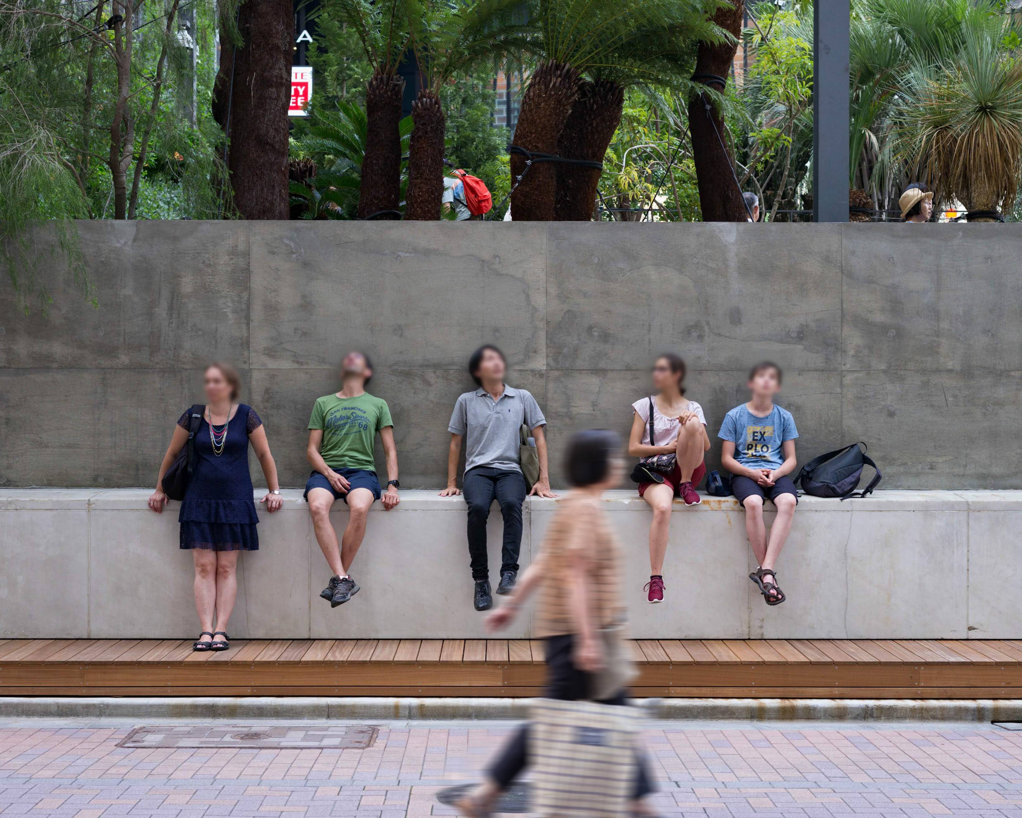 A hands-on experience. Visitors to Ginza lounge on the curb on the Sony Street side of the park.