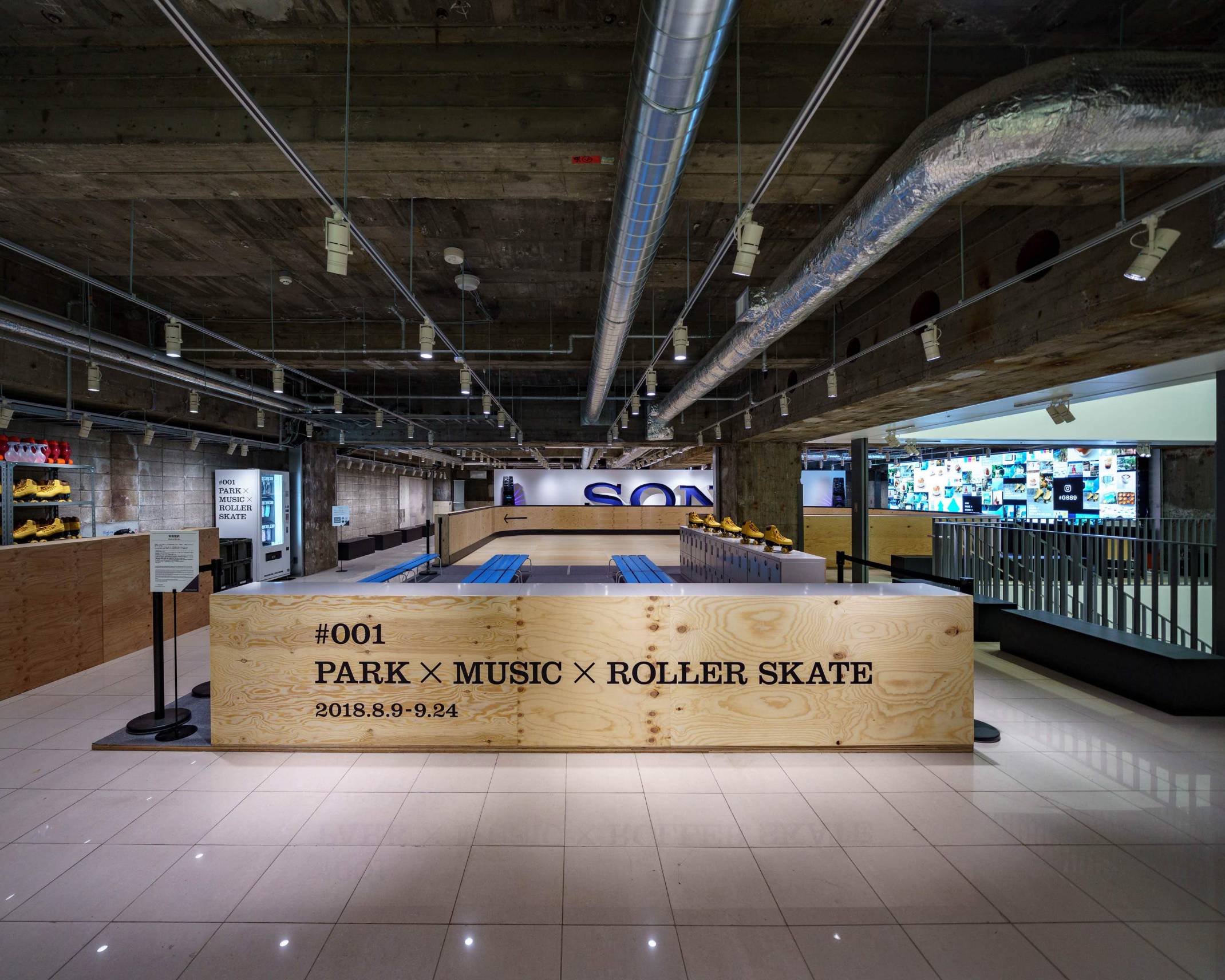 Exhibit. At the back of the roller skating rink, made of wooden planks, is a sign that says “SONY.”