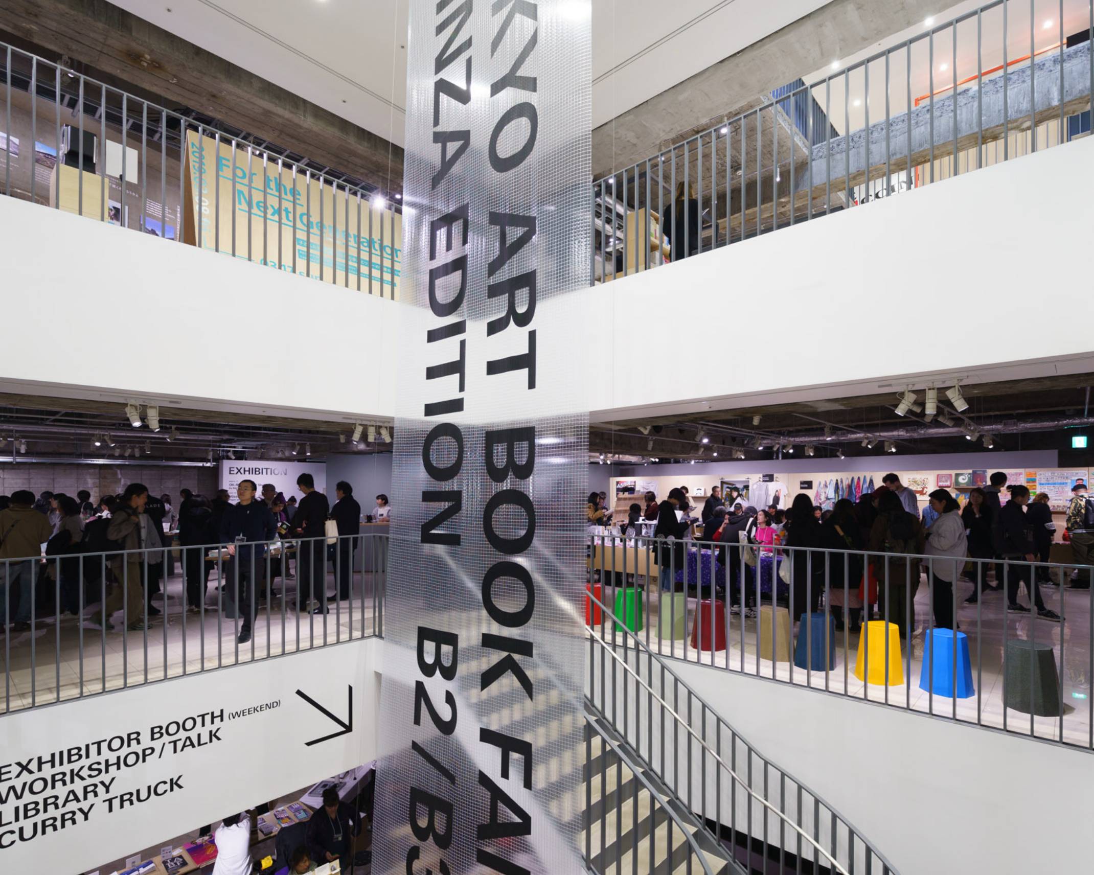 Venue. A vertical banner is displayed in the underground area of the atrium; many visitors can be seen on each floor.
