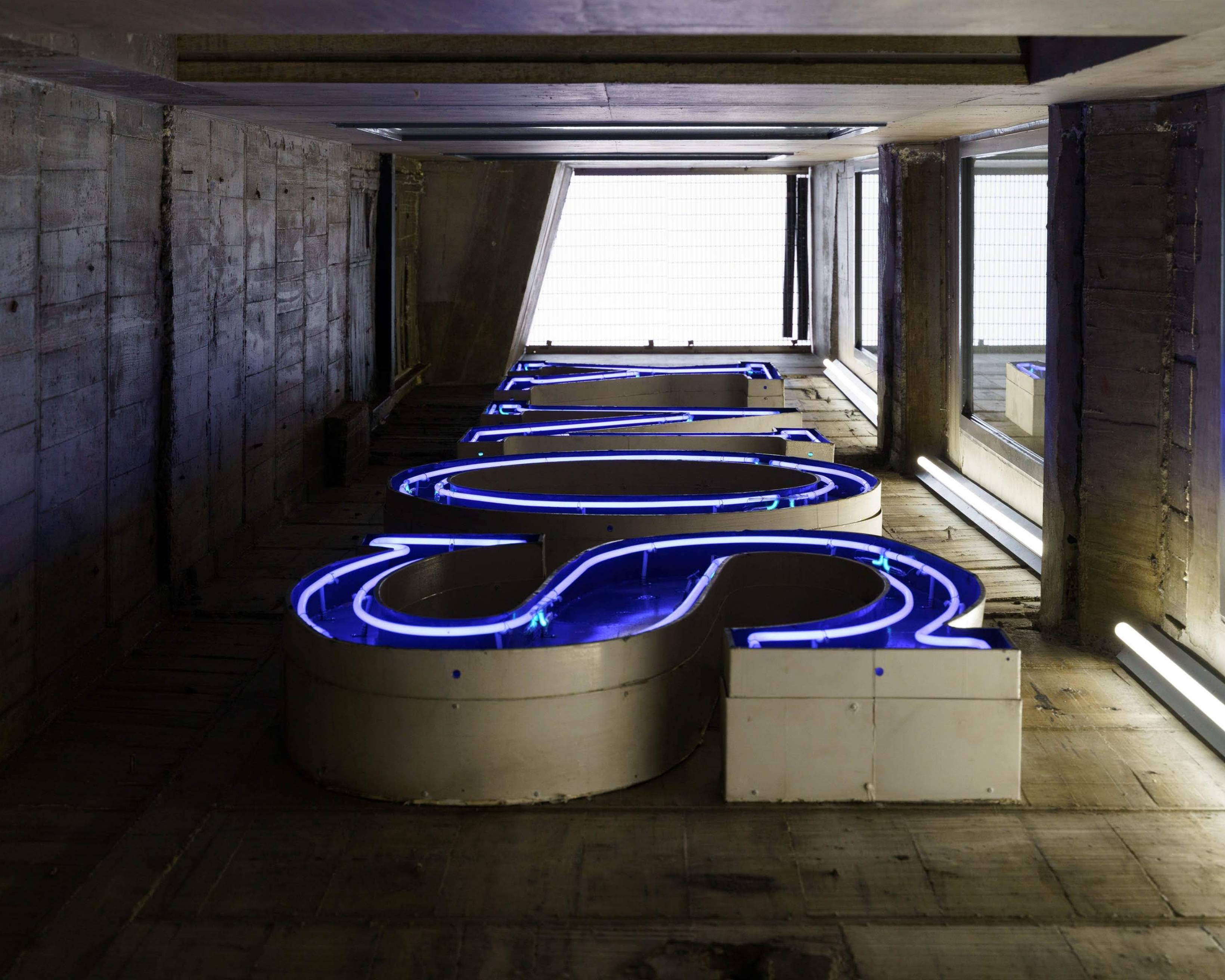 Neon sign. The neon “SONY” sign from the Sony Building era glows blue in its display in the vertical shaft compartment of the building.