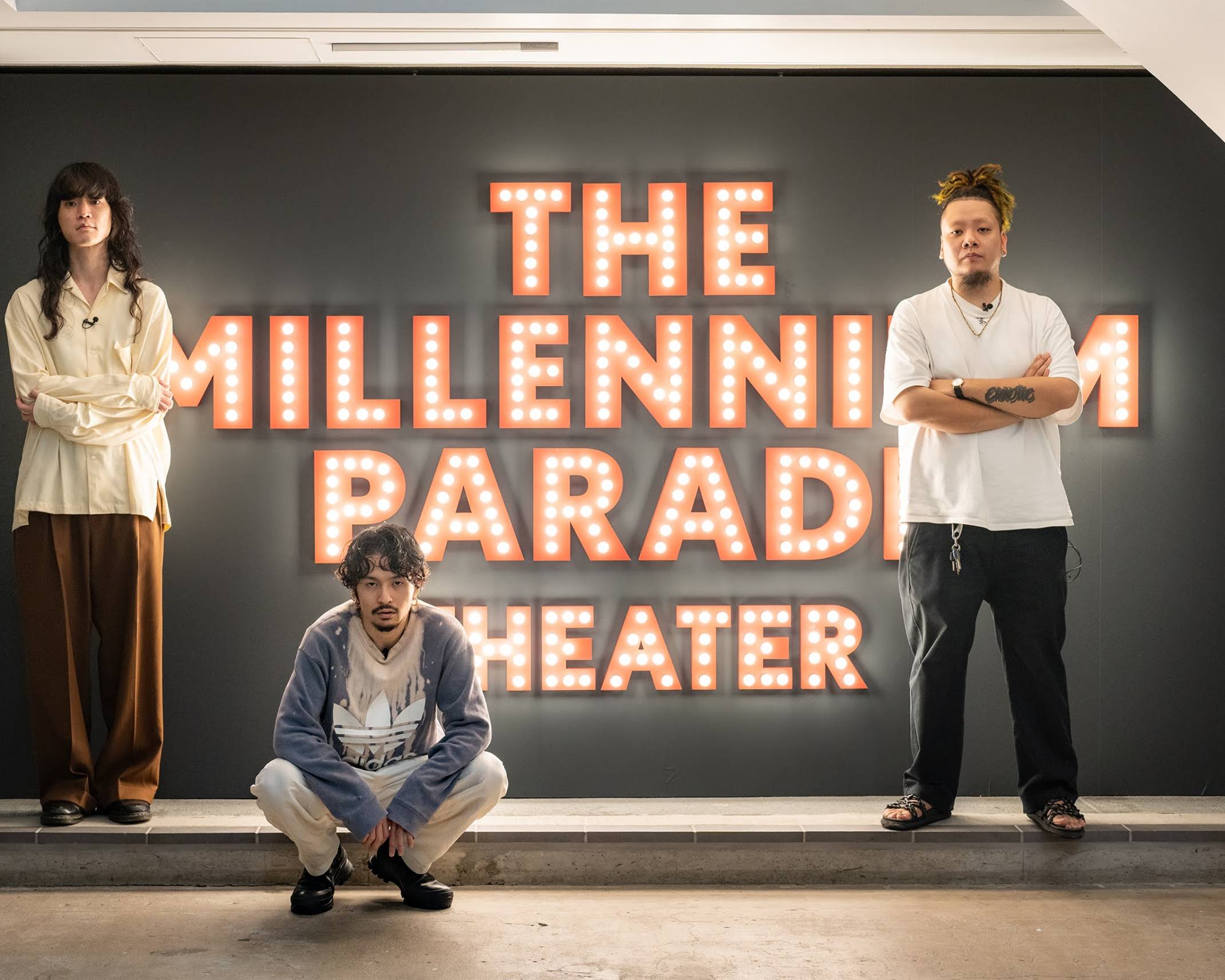 Exhibit. Members of the millennium parade pose in front of the theater sign.