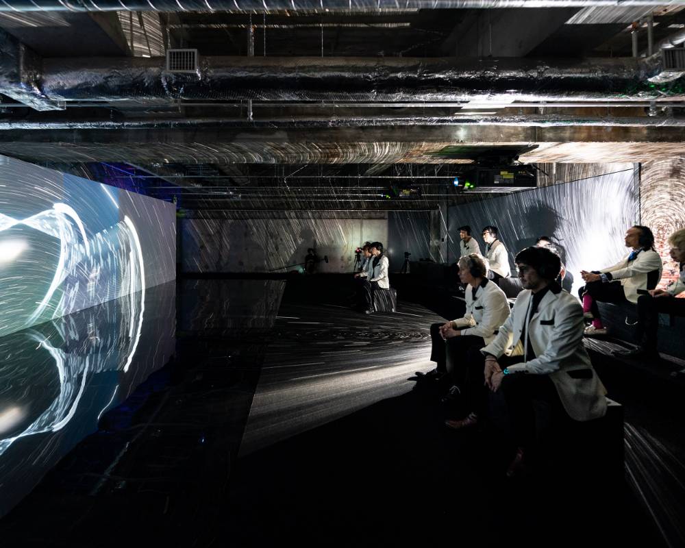 A hands-on experience. Members of the TOKYO SKA PARADISE ORCHESTRA experiencing the Planet Poem, which has been projected prominently onto the wall.