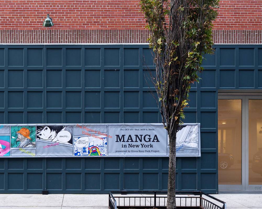 Exterior. The “MANGA in New York” sign hanging on a dark teal tiled wall.