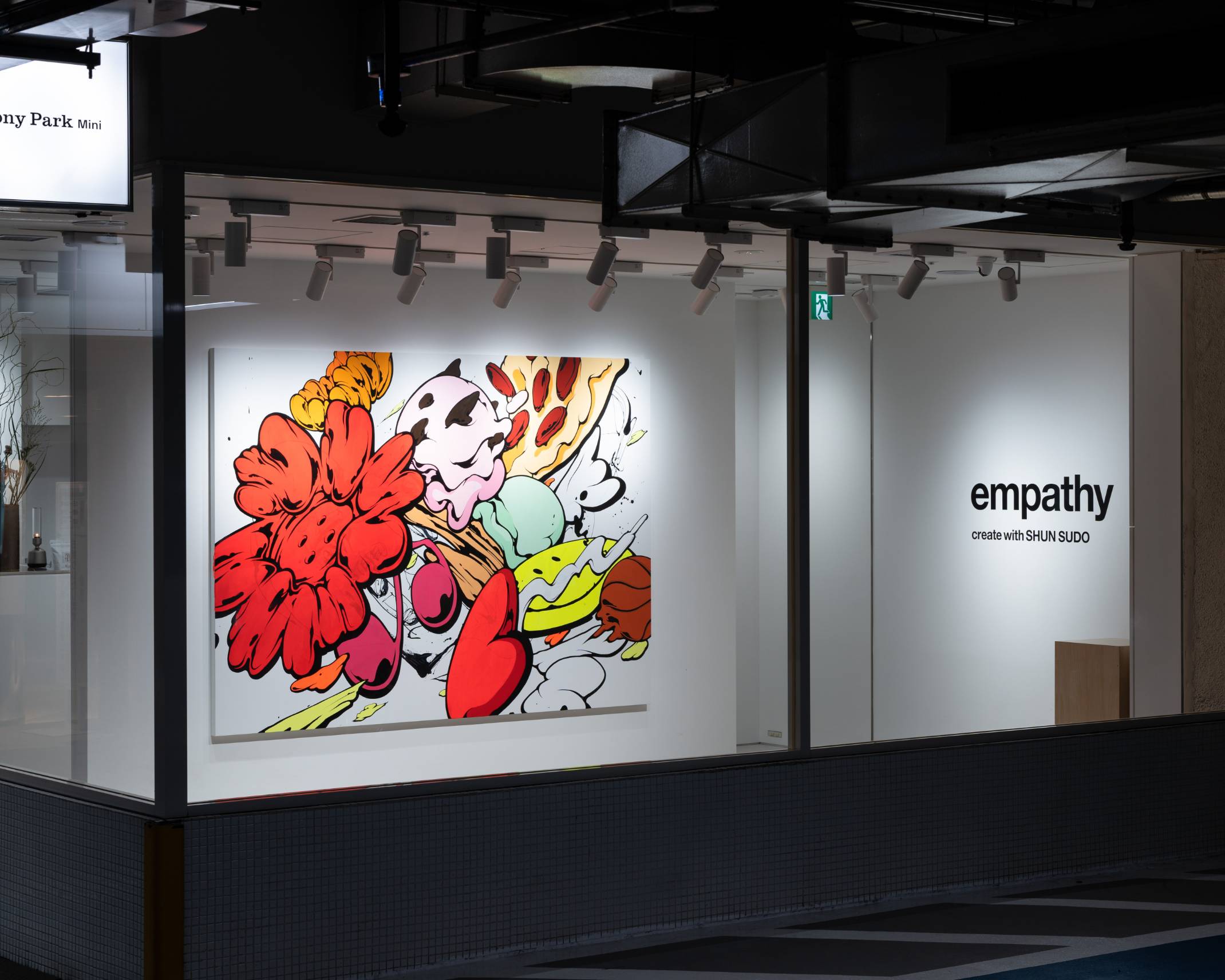 Exterior. An art piece with a strikingly large red flower adorns the wall of the exhibition space.