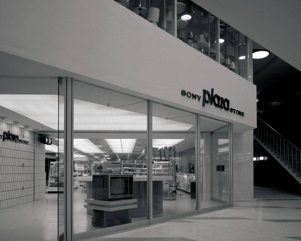 Basement exterior (black-and-white). The sign for the Sony Plaza Store is displayed where the building connects to the Ginza Station underground concourse.